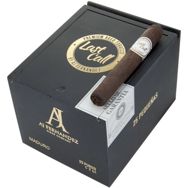 Last Call Pequenas Maduro från Nicaragua, mörk cigarr med vit gördel ovanpå svart cigarrlåda från AJ Fernandez.